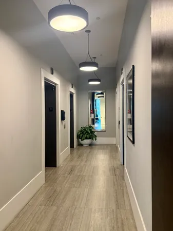 a view of a hallway with wooden floor and a chandelier
