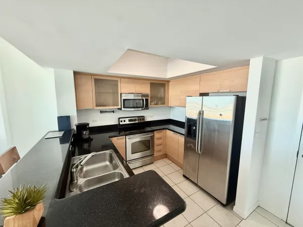 a kitchen with stainless steel appliances granite countertop a stove a sink and a refrigerator