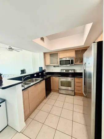 a kitchen with stainless steel appliances kitchen island granite countertop a stove a sink and a refrigerator