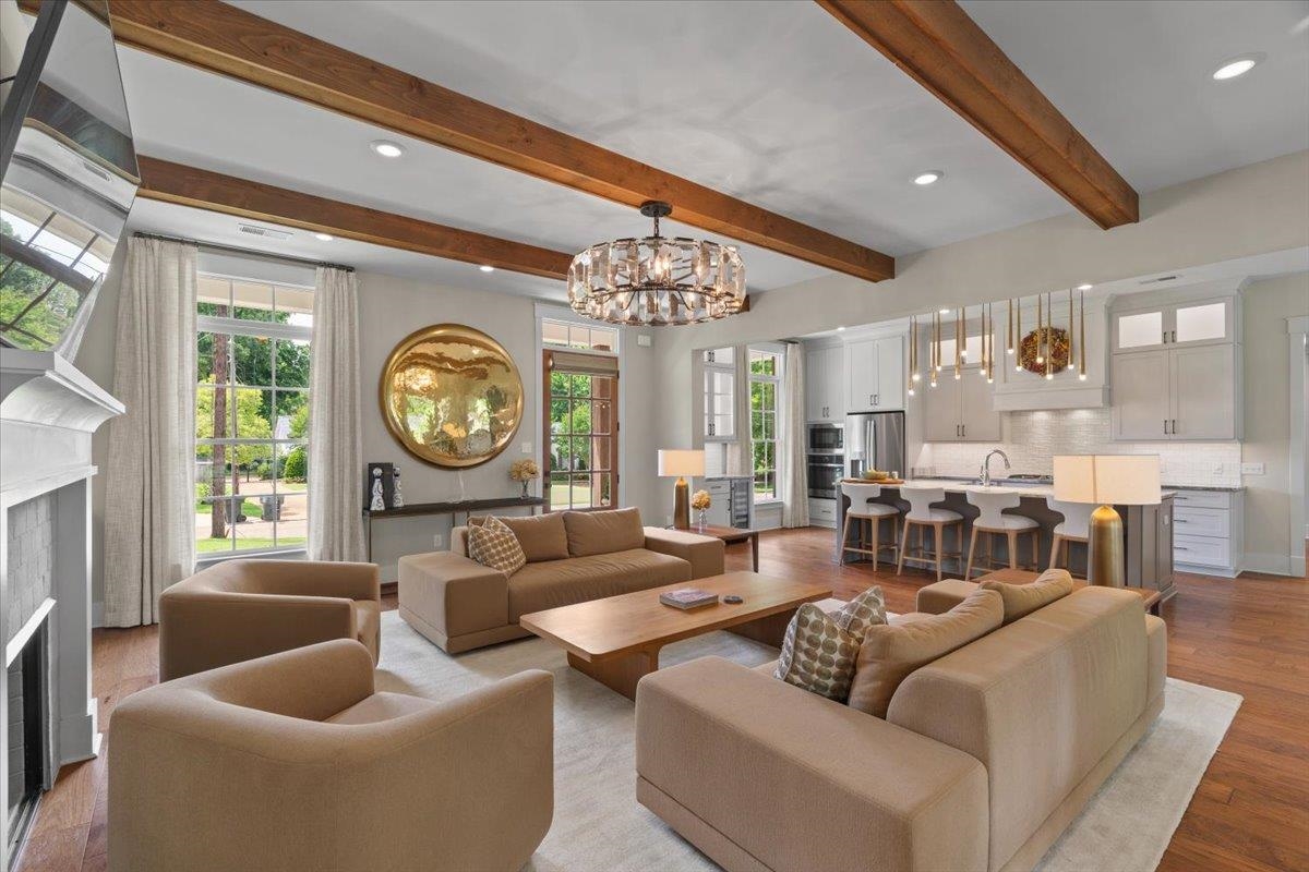 240 Burrows Road Collierville, TN 38017 - Photo 7 of 37 Open-concept living space featuring wood-finish flooring, exposed ceiling beams, a fireplace with a mantel, and large windows