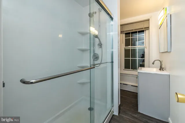 a bathroom with a sink mirror and shower