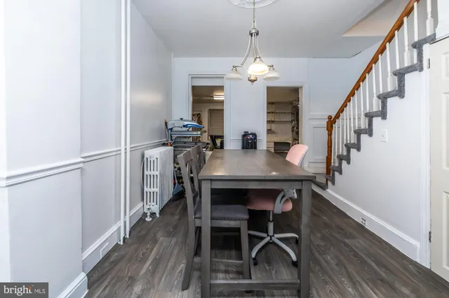 a view of a dining room with furniture a chandelier and wooden floor