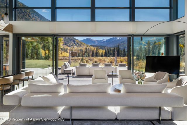 a living room with couches and a table with garden view