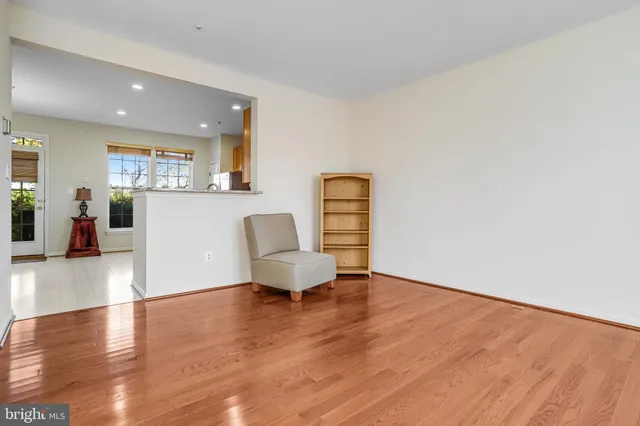 a kitchen with stainless steel appliances granite countertop white cabinets a refrigerator a stove a oven a sink and dishwasher with wooden floor