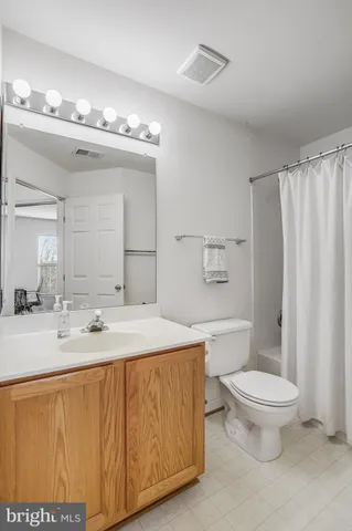a view of a room with gym equipment and wooden floor