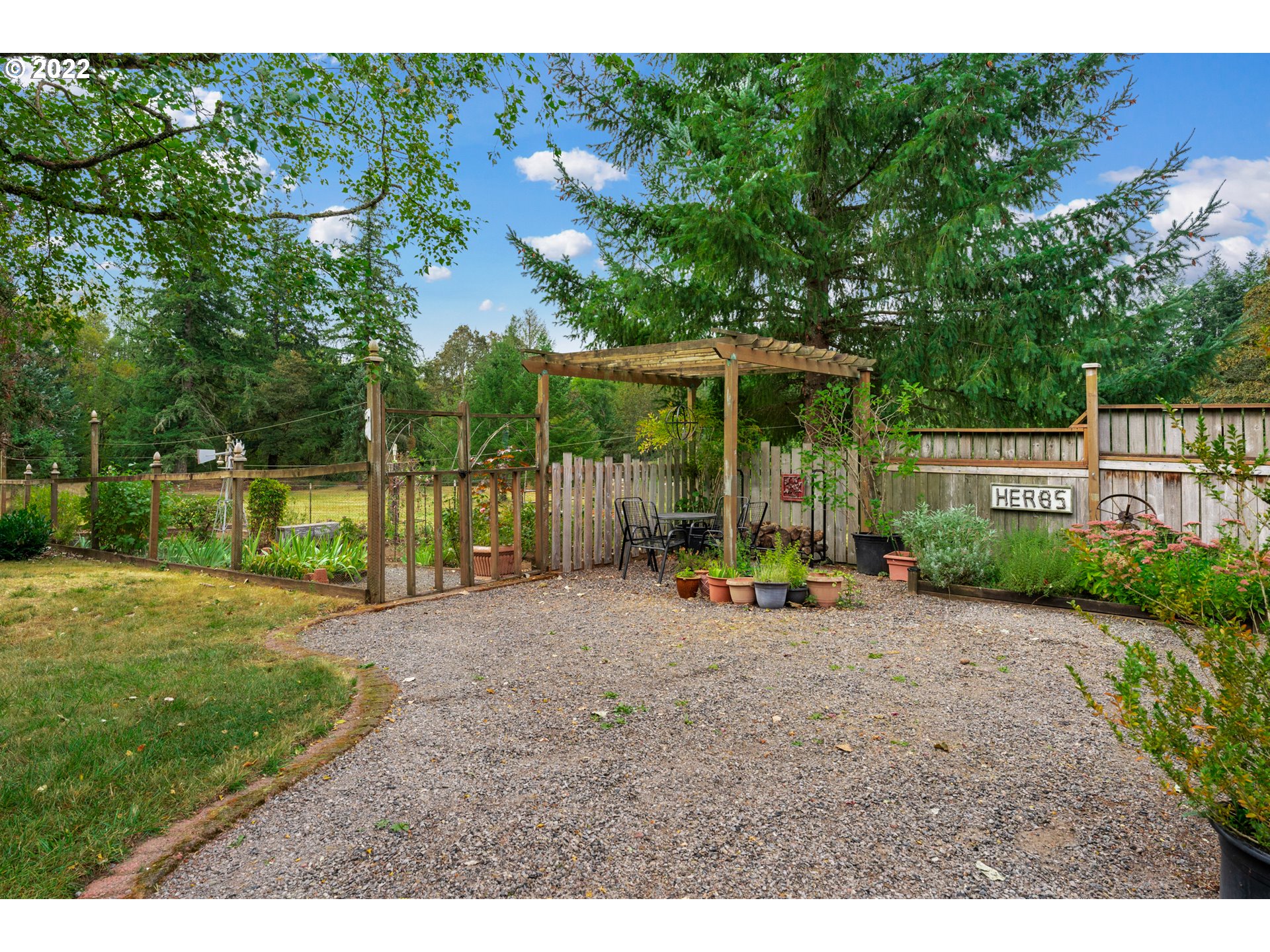 22913 Northeast 16th Street Camas, WA 98607 - Photo 24 of 32 a view of a backyard with a slide trees and wooden fence