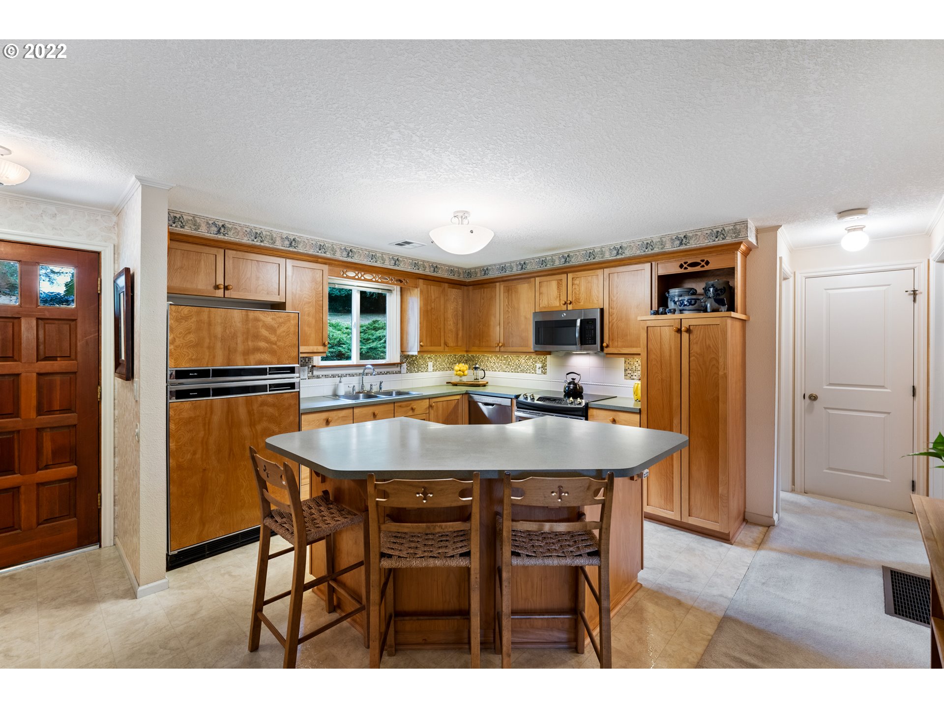 22913 Northeast 16th Street Camas, WA 98607 - Photo 5 of 32 a dining room with stainless steel appliances kitchen island granite countertop a refrigerator a stove a sink with island and chairs
