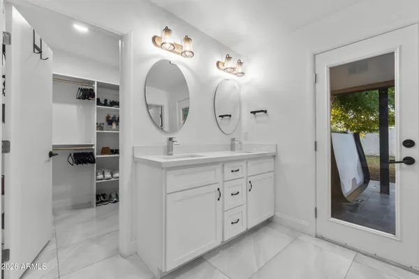 a spacious bathroom with a double vanity sink mirror and shower