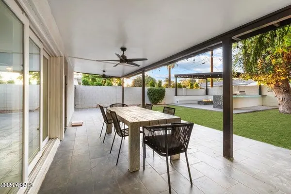 a view of a patio with a table chairs and a backyard