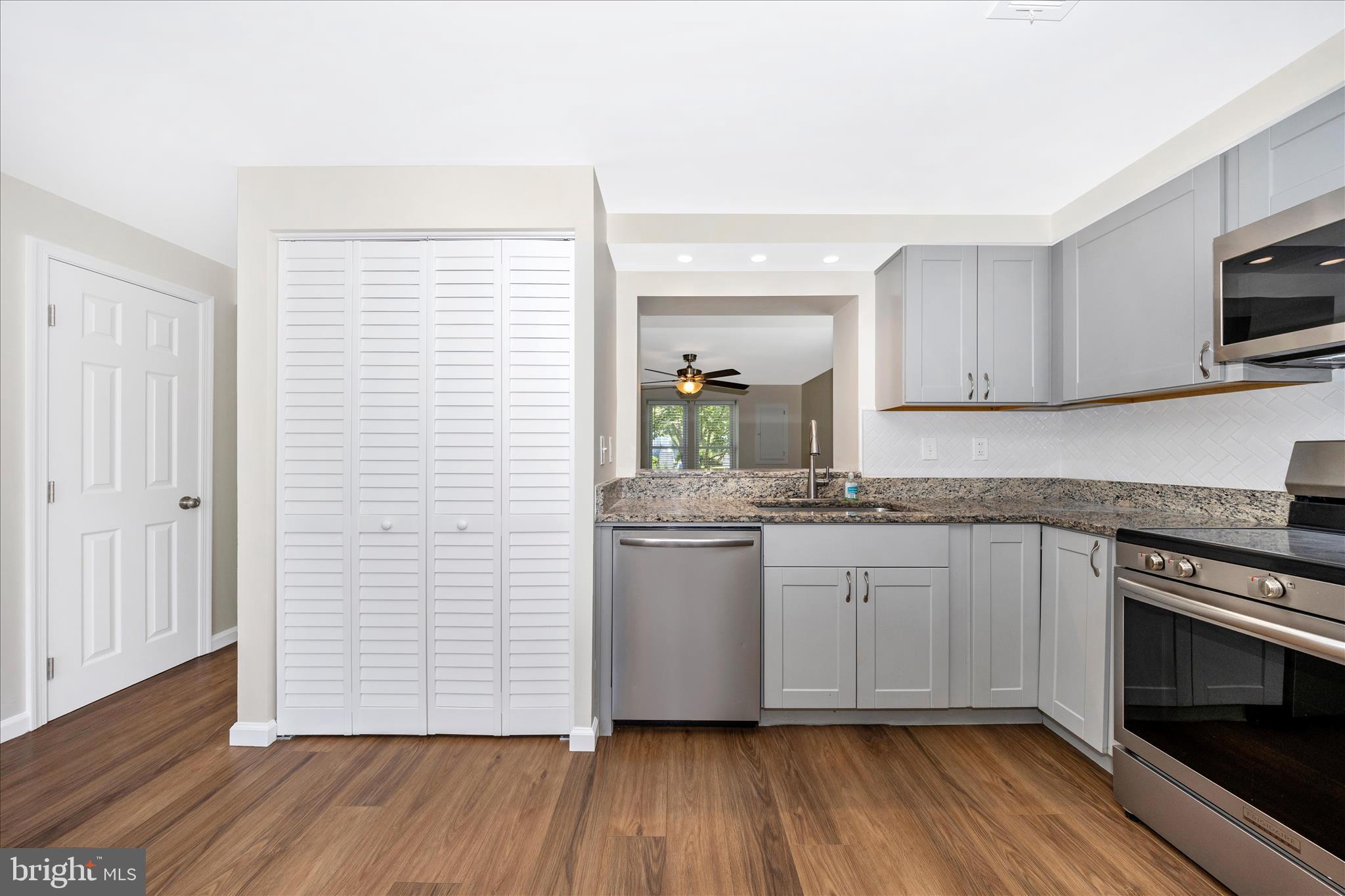 1369 David Lane Frederick, MD 21703 - Photo 20 of 53 a kitchen with stainless steel appliances granite countertop wooden floors and white cabinets
