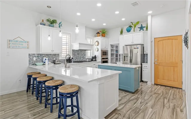 a kitchen with stainless steel appliances granite countertop a table chairs sink and cabinets