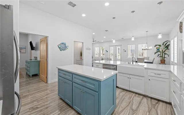 a room with kitchen island a sink and a stove top oven