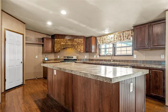 a view of a kitchen with furniture and wooden floor