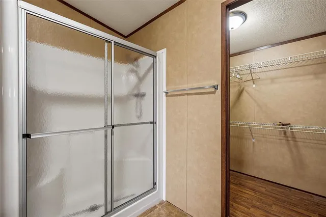 a bathroom with a granite countertop sink two mirror and shower