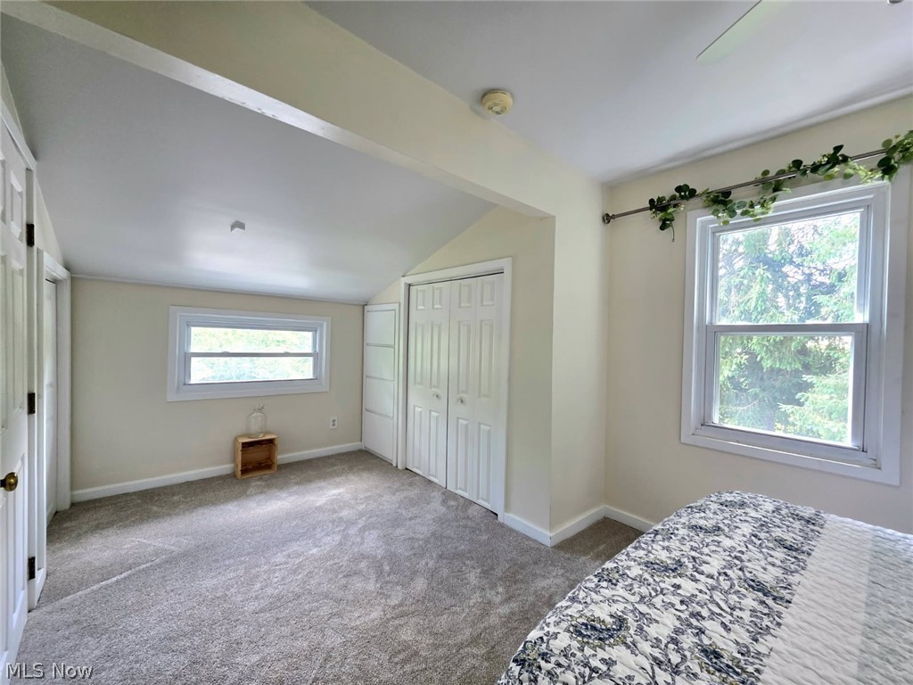 398 North Chillicothe Road Aurora, OH 44202 - Photo 31 of 39 Carpeted room featuring multiple windows, sloped ceilings, and two sets of bi-fold closet doors