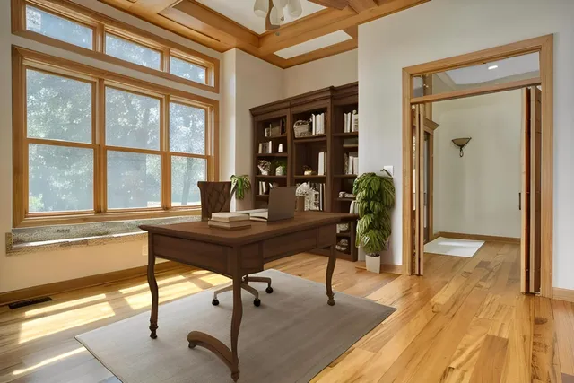 a view of an empty room with a window and wooden floor