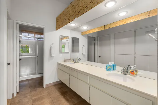 a bathroom with double vanity and a mirror