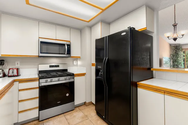 a kitchen with stainless steel appliances granite countertop a refrigerator and a stove top oven
