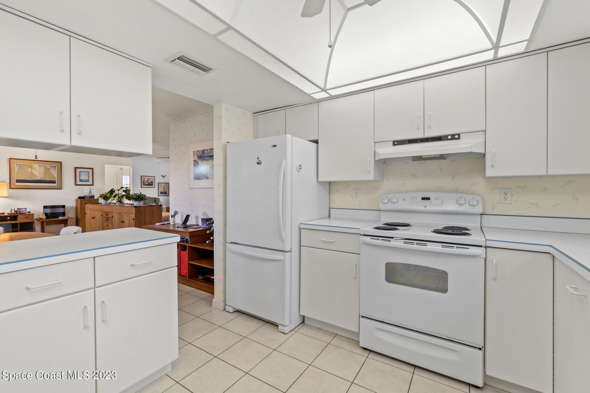 209 River Road Satellite Beach, FL 32937 - Photo 24 of 86 a kitchen with white cabinets and white appliances