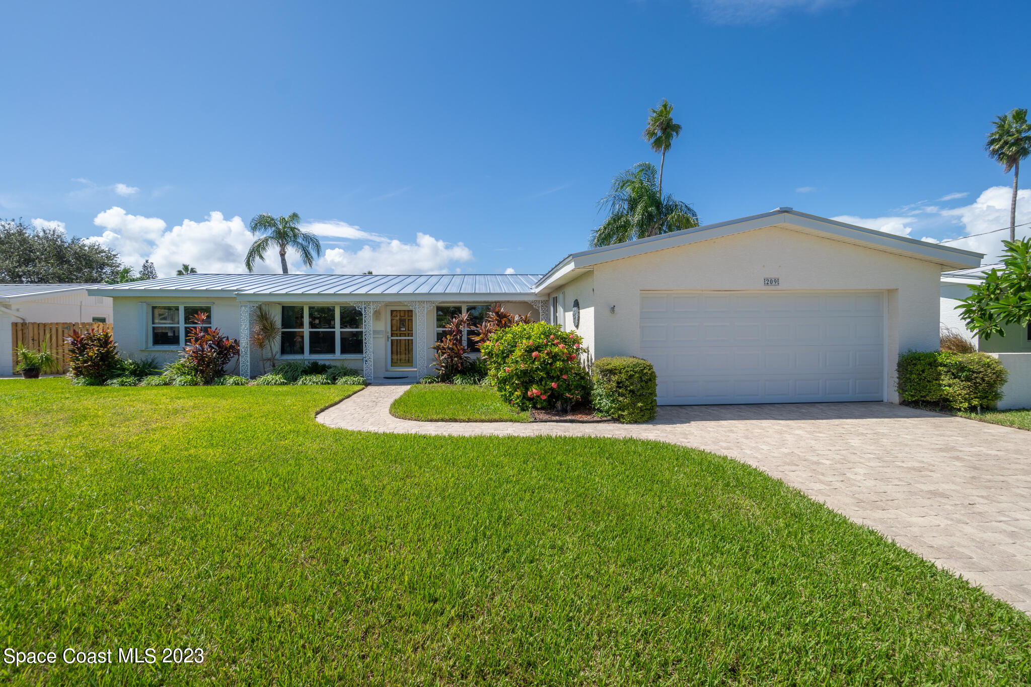 209 River Road Satellite Beach, FL 32937 - Photo 29 of 86 a front view of a house with a yard and potted plants