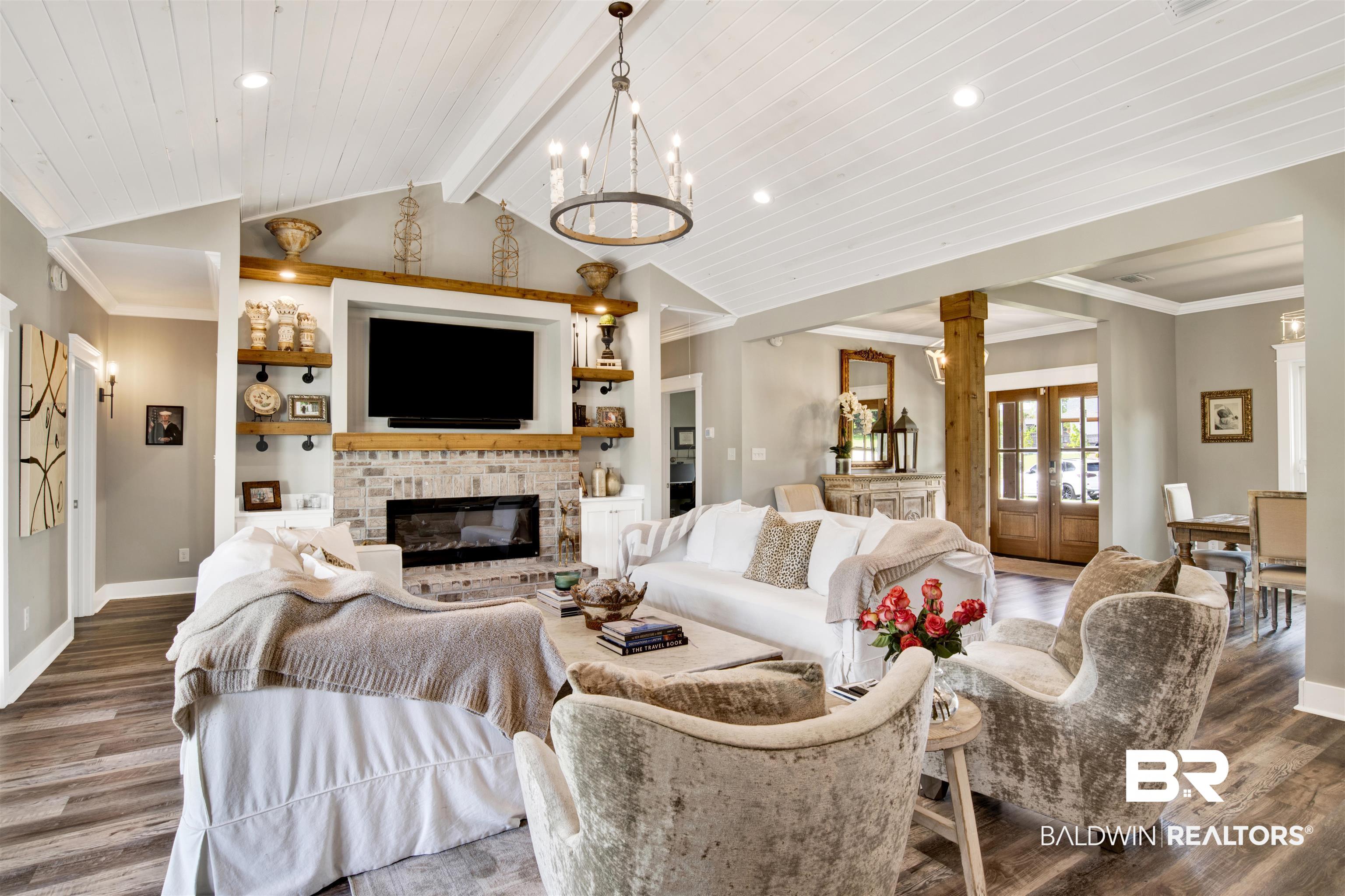 21621 Veranda Boulevard Fairhope, AL 36532 - Photo 21 of 51 Living area featuring baseboards, vaulted ceiling with beams, a brick fireplace, and wood finished floors