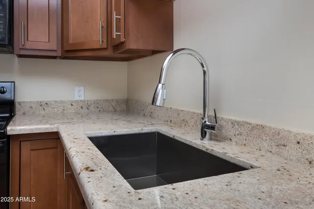 a kitchen with granite countertop a sink and a stove