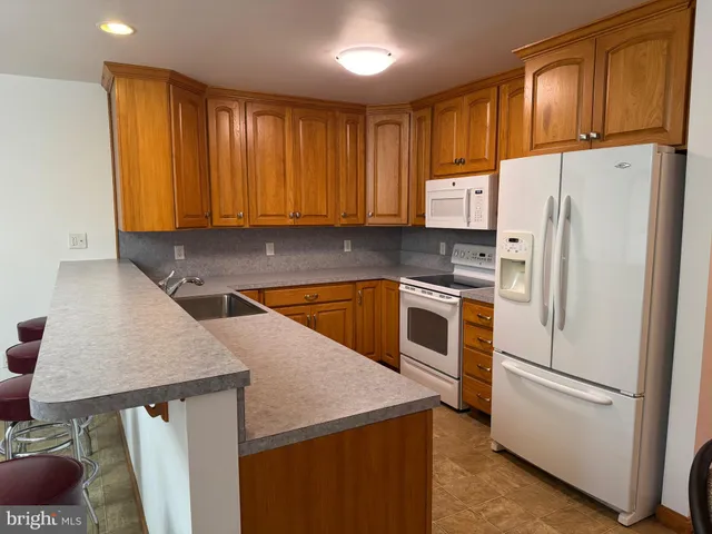 a kitchen with wooden cabinets and white appliances