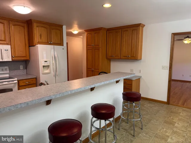 a kitchen with stainless steel appliances granite countertop a sink and a refrigerator