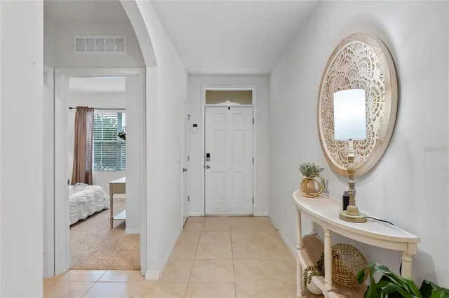 a view of a hallway with entryway wooden floor and a chandelier