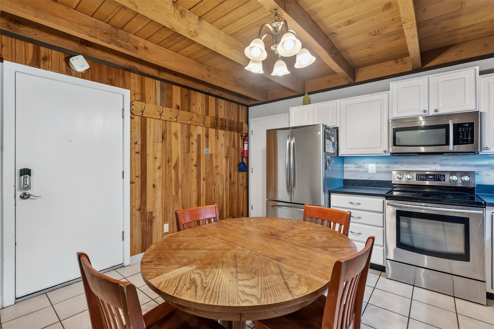 8100 Ryan Gulch Road, Unit 106 Wildernest, CO 80498 - Photo 7 of 43 a kitchen with stainless steel appliances granite countertop a stove a refrigerator a microwave oven with a dining table and chairs