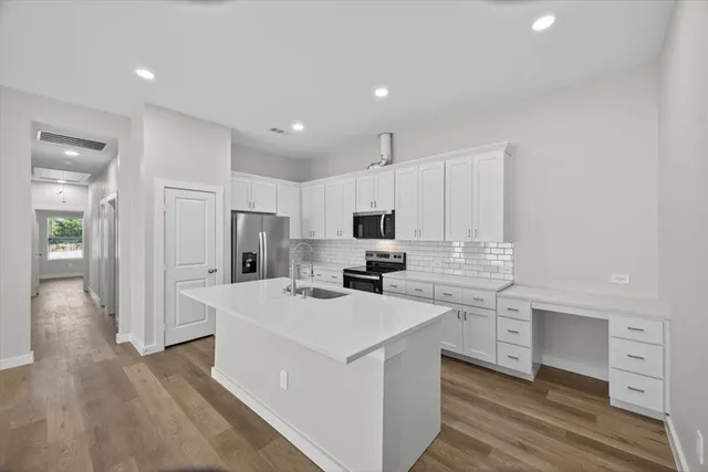 a kitchen with a sink a counter top space stainless steel appliances and cabinets
