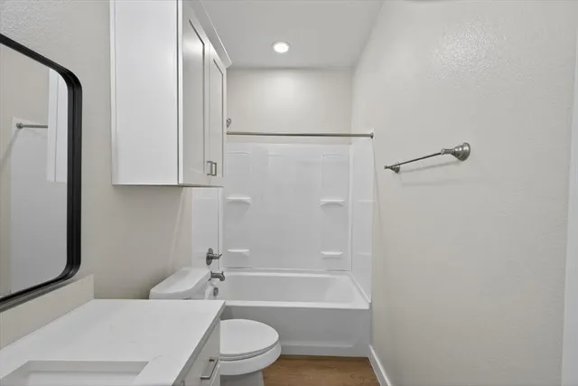 a view of empty room with wooden floor and ceiling fan