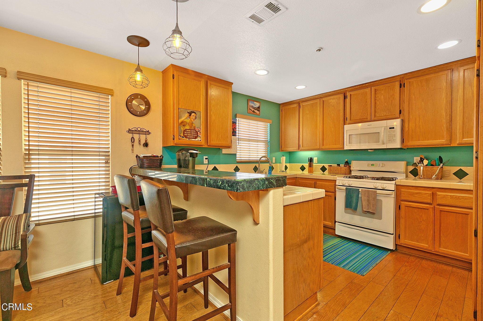 11172 Darling Road Ventura, CA 93004 - Photo 13 of 31 a kitchen with stainless steel appliances granite countertop a stove a sink dishwasher and a refrigerator with wooden floor