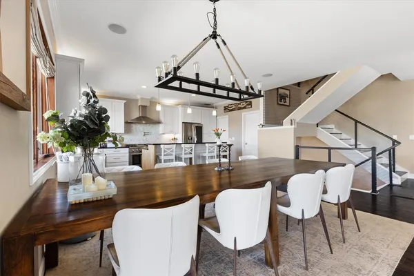 a view of a dining room with furniture a rug and wooden floor