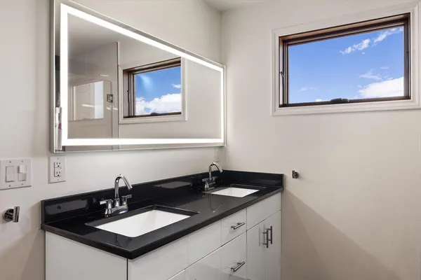 a bathroom with a granite countertop sink and a mirror