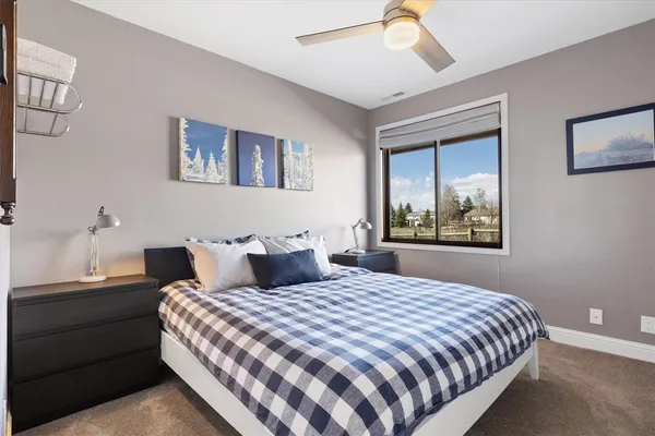 a bedroom with a bed and a flat tv screen on a dresser