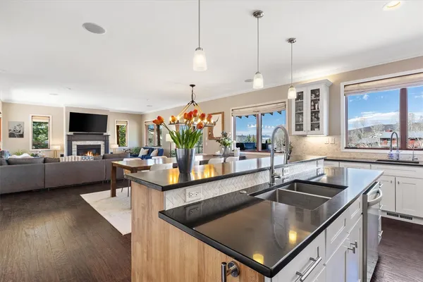 a kitchen with stainless steel appliances granite countertop a sink a stove and a wooden floors