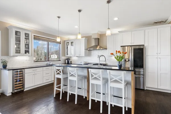 a kitchen with granite countertop white cabinets and stainless steel appliances