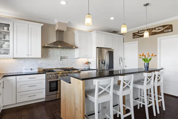 a kitchen with stainless steel appliances granite countertop a stove a sink and a refrigerator