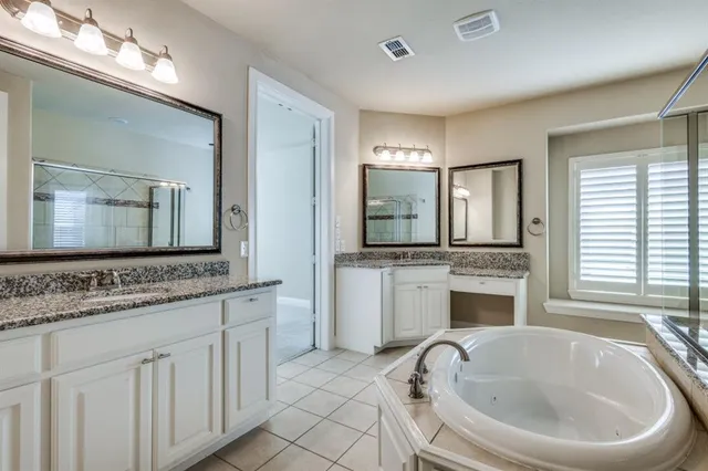 a spacious bathroom with a granite countertop tub sink and mirror