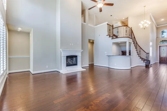 an empty room with stainless steel appliances kitchen island wooden floors and view living room
