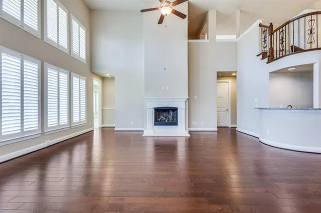 an empty room with wooden floor and a fireplace