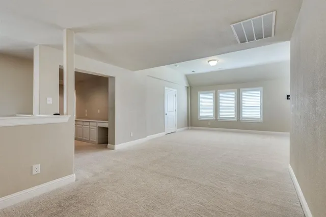 a view of an empty room with a kitchen