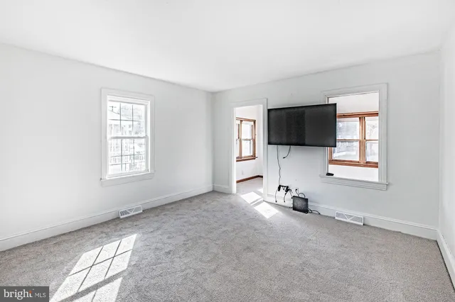 an empty room with windows and tv