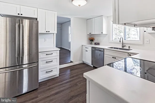 a kitchen with granite countertop a refrigerator stove and sink