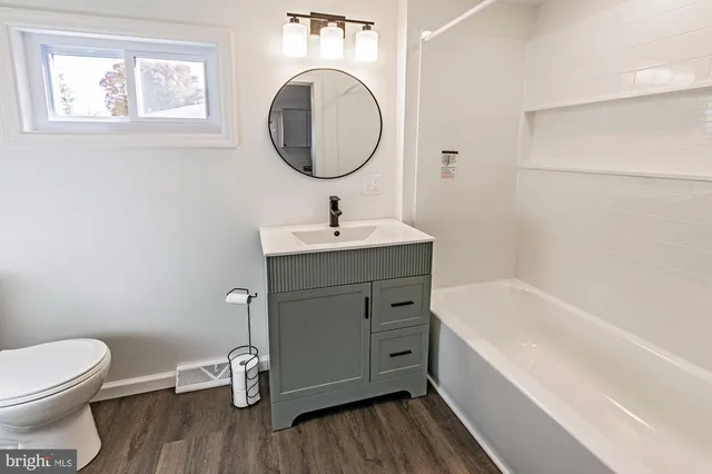 a bathroom with a sink mirror vanity and toilet