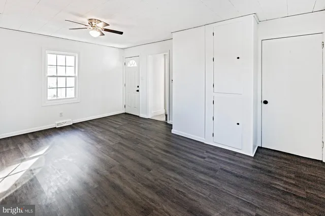a view of an empty room with wooden floor