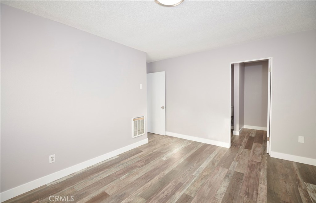 4723 Jackson Street, Unit 28 Riverside, CA 92503 - Photo 26 of 33 an empty room with wooden floor and windows