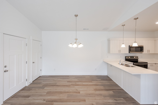693 West 4500th South, Unit O303 Mapleton, UT 84664 - Photo 13 of 15 Kitchen with white cabinetry, a peninsula, electric stove, light wood-type flooring, and hanging lights
