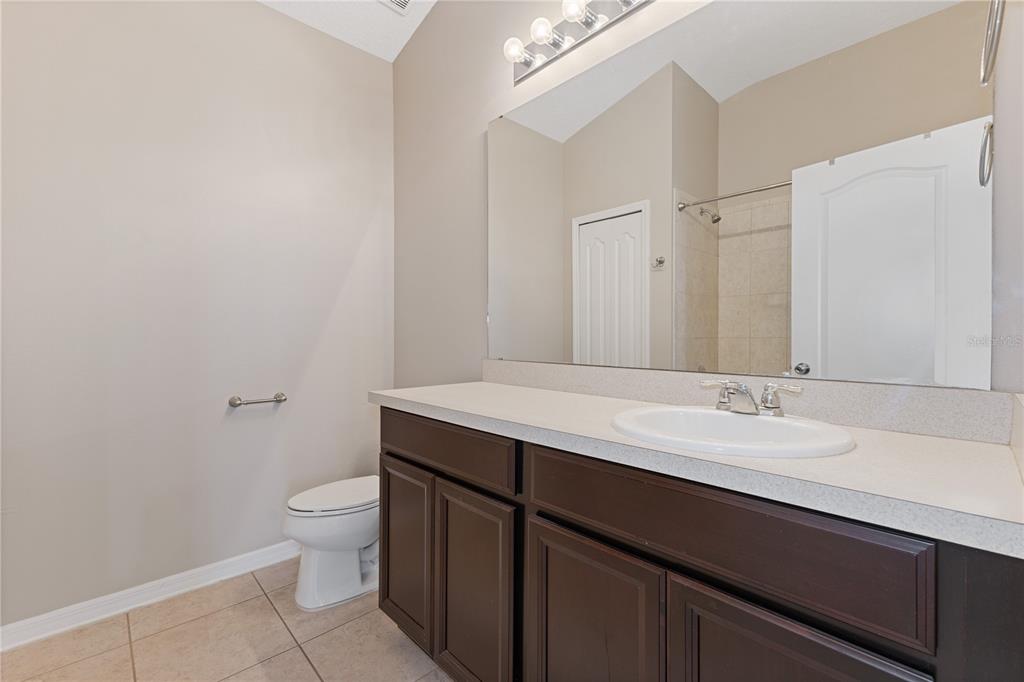 506 Rainbow Springs Loop Groveland, FL 34736 - Photo 19 of 30 a bathroom with a granite countertop sink a toilet and a mirror